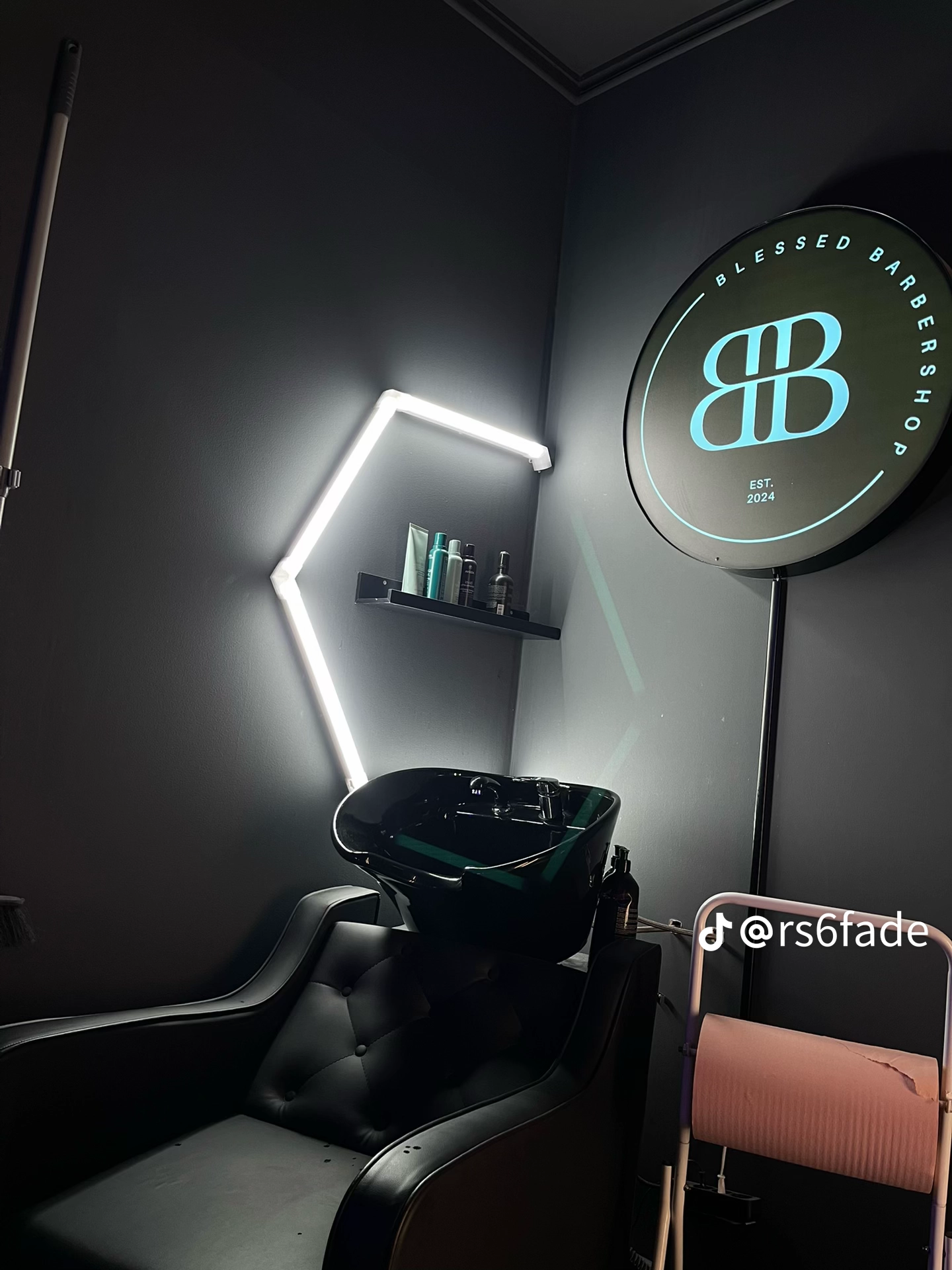 Hårtvättstation med belyst Blessed Barbershop-skylt